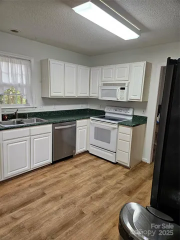 a kitchen with stainless steel appliances granite countertop a stove top oven a sink and dishwasher