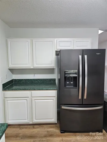a kitchen with granite countertop white cabinets and stainless steel appliances