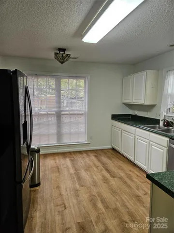 a view of a kitchen with a dishwasher cabinets and a window