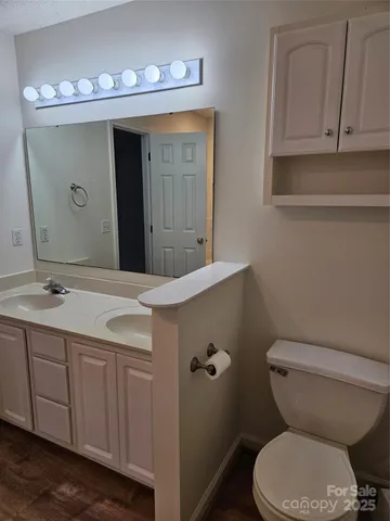 a bathroom with a granite countertop toilet sink and mirror