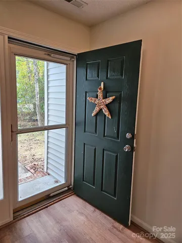a view of a hallway with wooden floor and windows