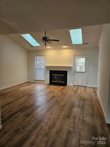 an empty room with windows and fireplace