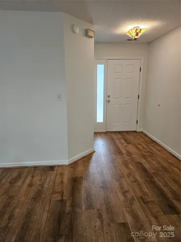 a view of an empty room with closet and wooden floor
