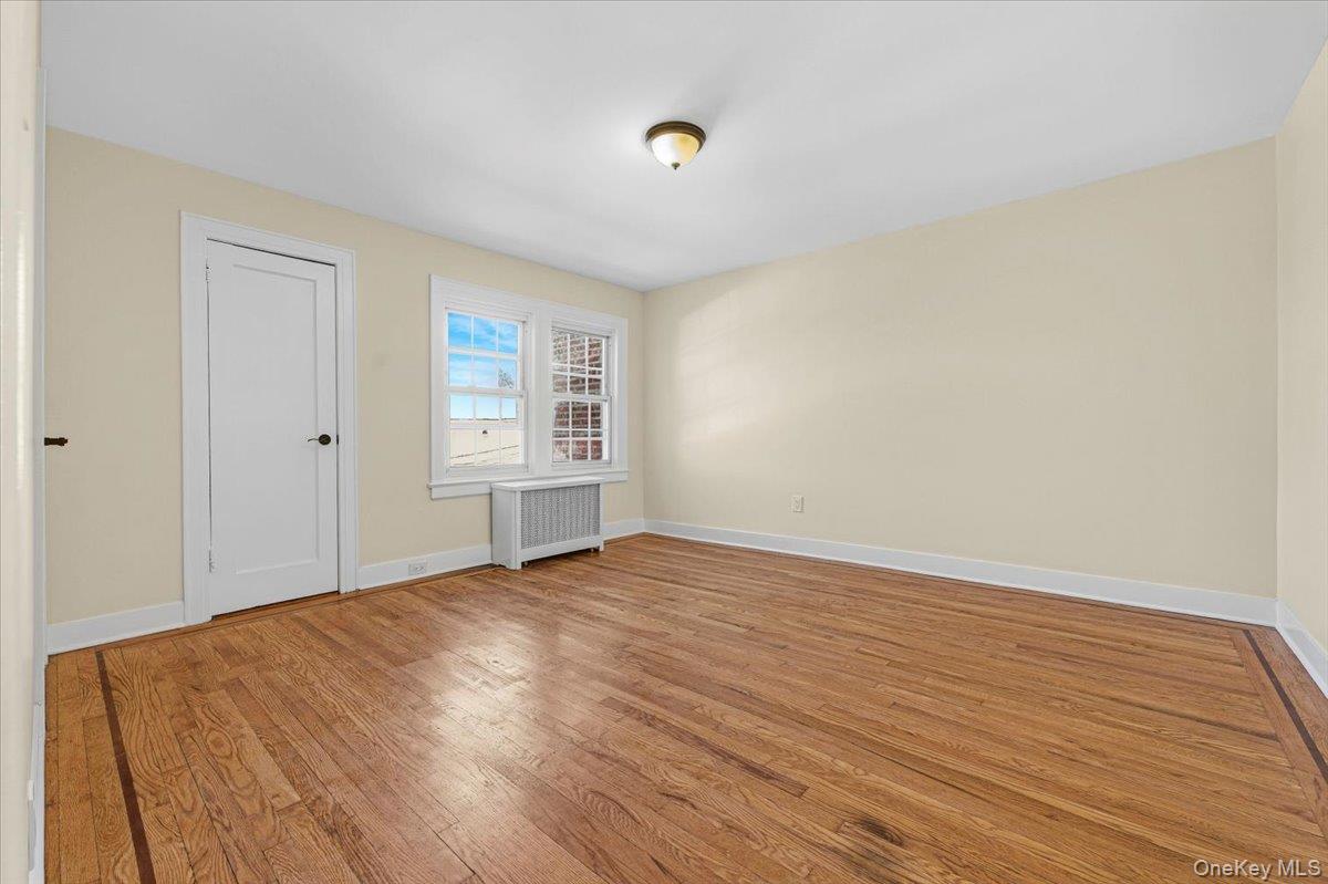 179-67 Selover Road Queens, NY 11434 - Photo 17 of 49 a view of an empty room with wooden floor and a window