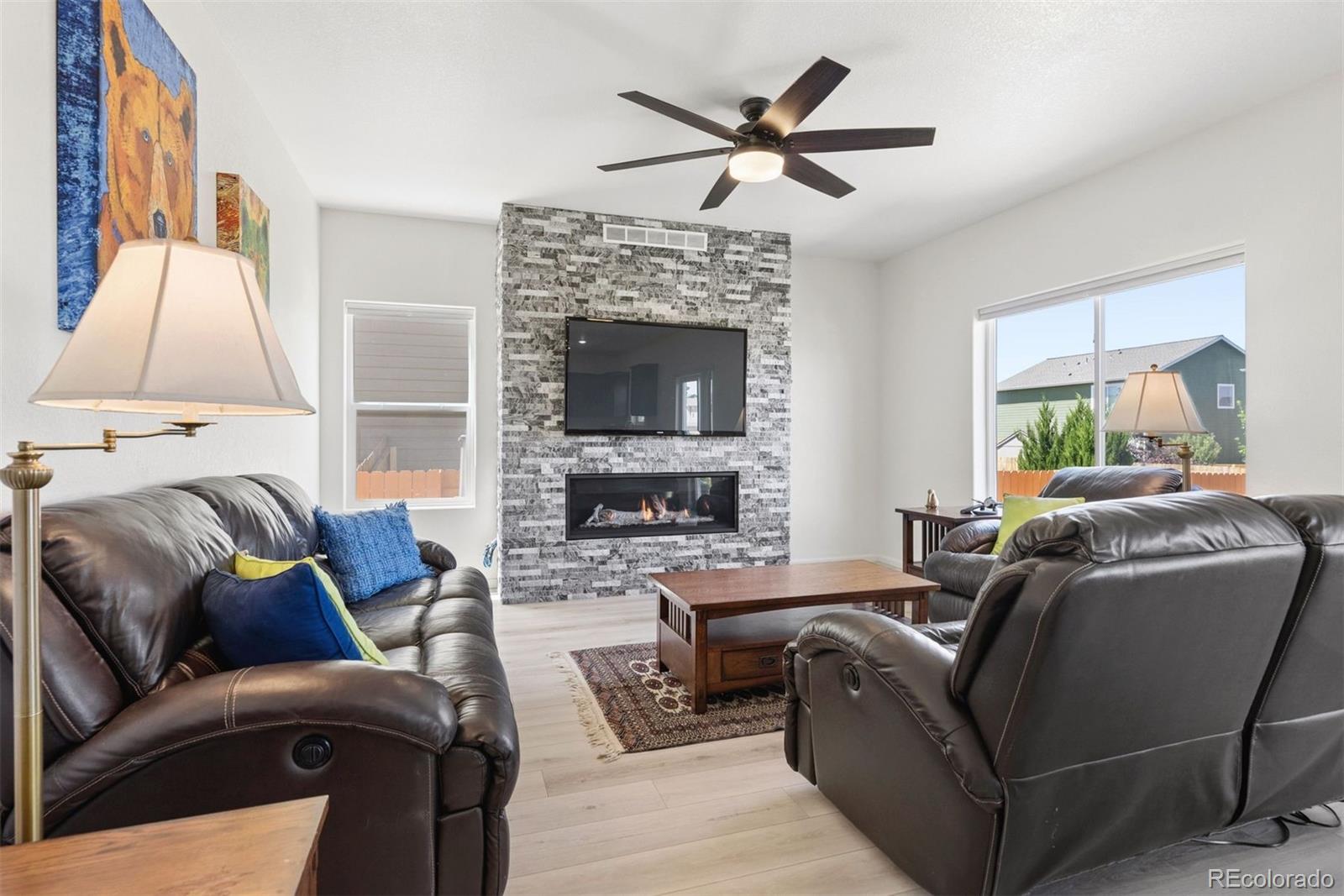 7307 Animas Avenue Frederick, CO 80530 - Photo 11 of 49 a living room with furniture a fireplace and a flat screen tv