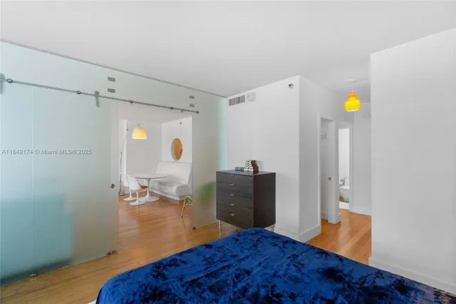 a view of a bedroom with wooden floor and furniture