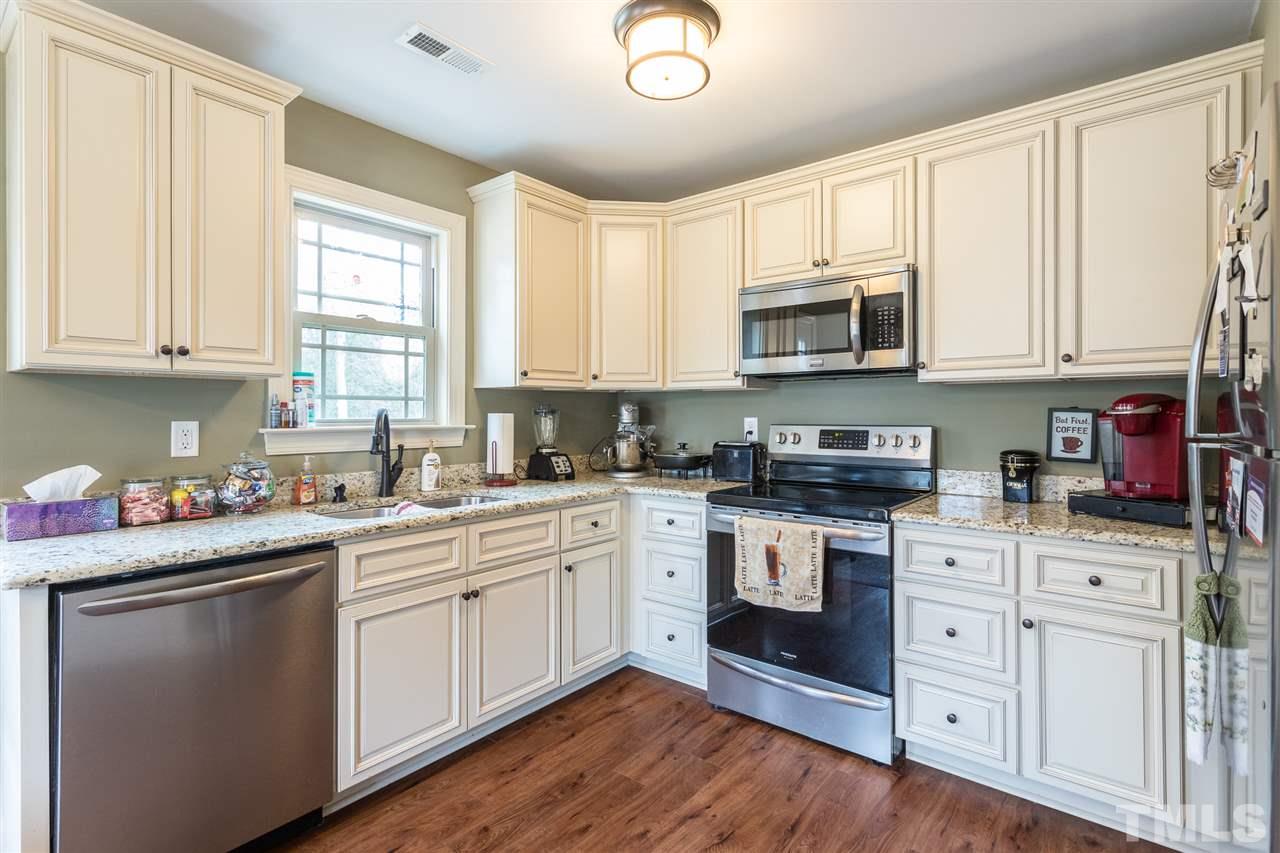 70 Young Road Angier, NC 27501 - Photo 4 of 8 a kitchen with stainless steel appliances granite countertop a sink a stove cabinets and wooden floor