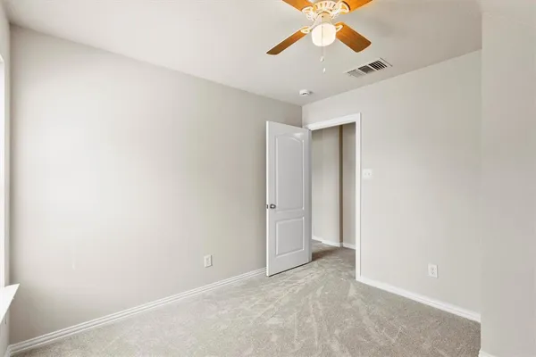 an empty room with window and a ceiling fan