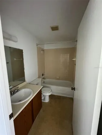 a bathroom with a granite countertop toilet sink and mirror