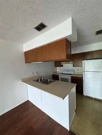 a kitchen with stainless steel appliances a sink dishwasher stove refrigerator and cabinets