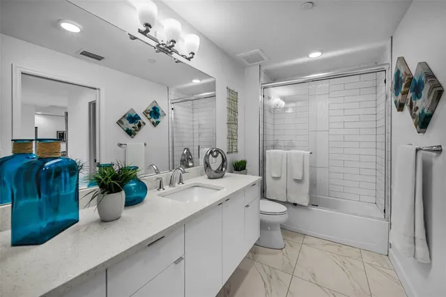 a bathroom with a double vanity sink toilet and shower