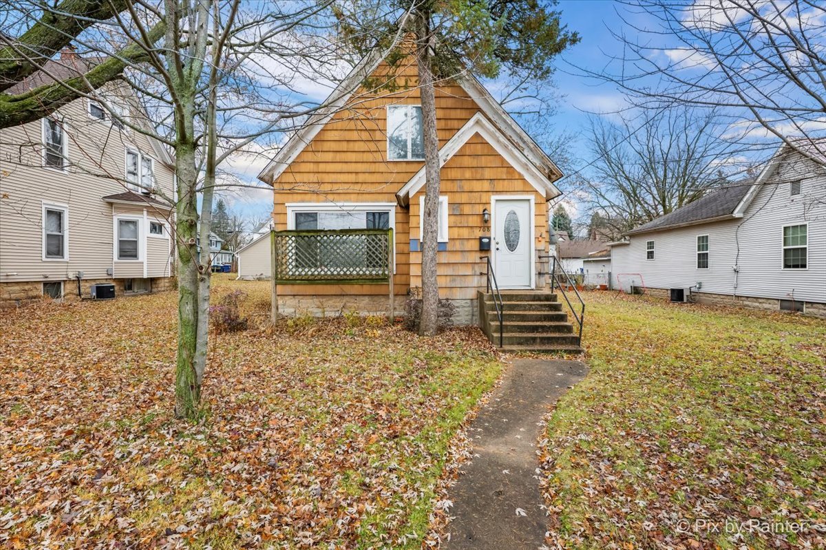 a view of a yard in front of a house with a large tree