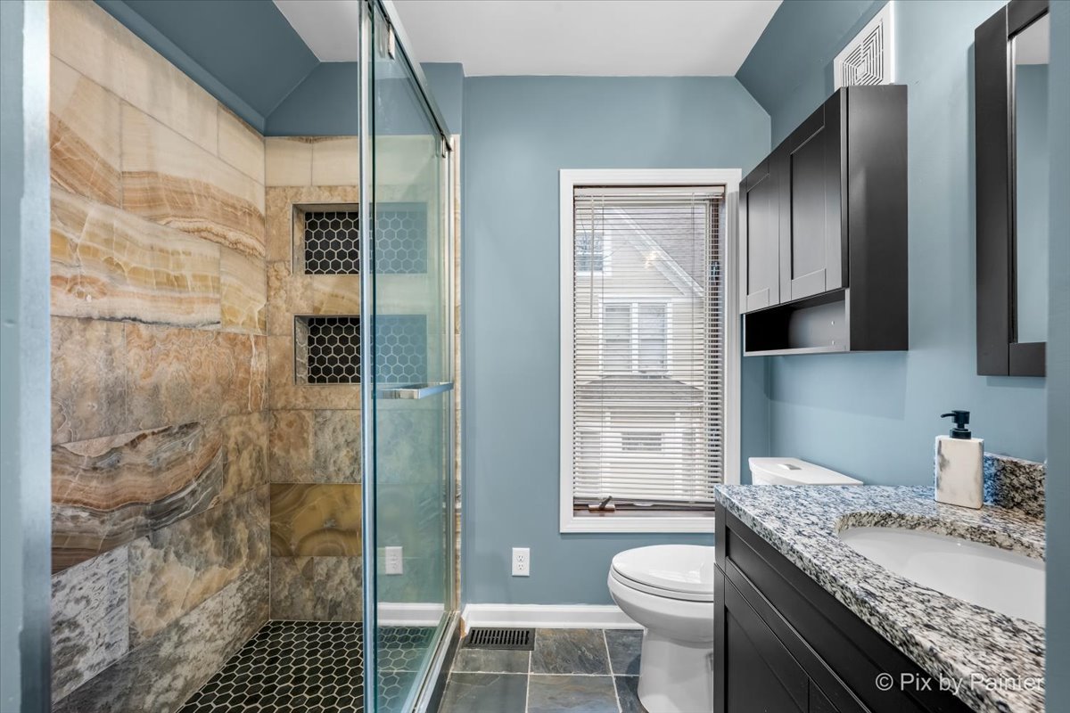 708 South 1st Street DeKalb, IL 60115 - Photo 12 of 17 a bathroom with a granite countertop sink toilet and shower
