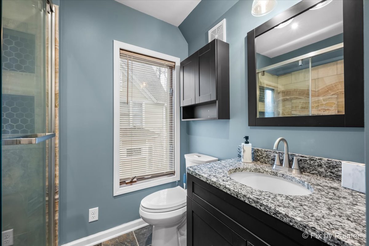 708 South 1st Street DeKalb, IL 60115 - Photo 13 of 17 a bathroom with a granite countertop sink a toilet and mirror