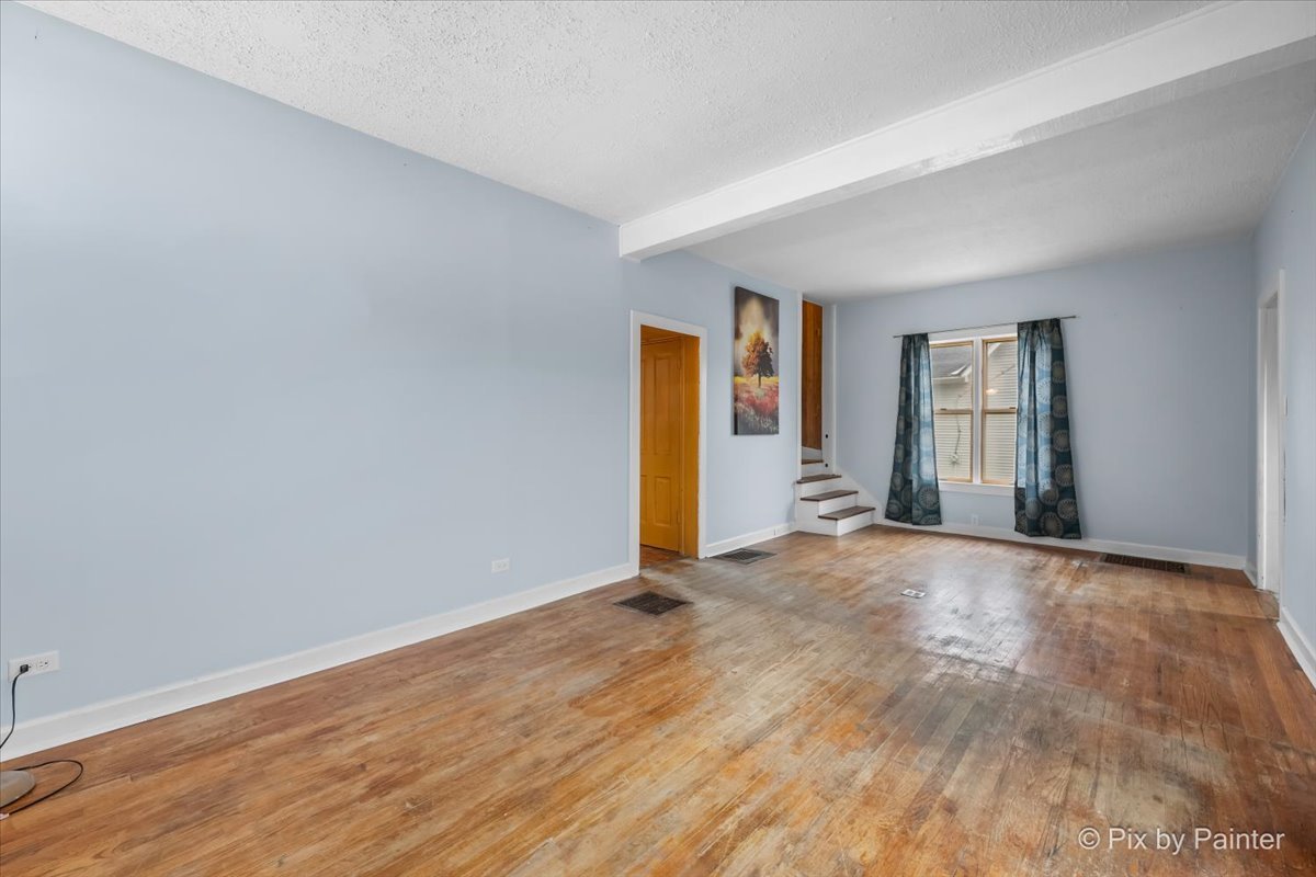 708 South 1st Street DeKalb, IL 60115 - Photo 3 of 17 a view of an empty room with window and wooden floor