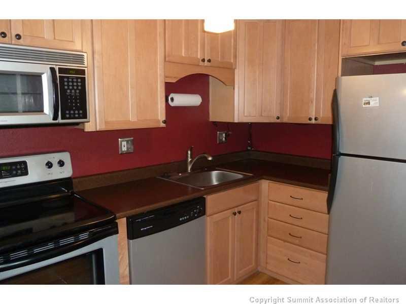 110 Evergreen Road, Unit 104B Dillon, CO 80435 - Photo 4 of 19 a kitchen with granite countertop a stove and a refrigerator