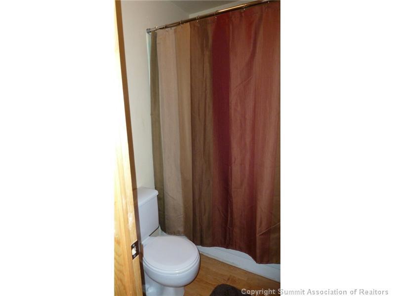 110 Evergreen Road, Unit 104B Dillon, CO 80435 - Photo 8 of 19 a white toilet sitting next to a wooden cabinet