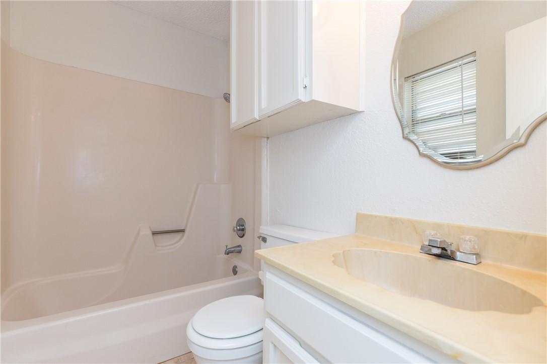 5133 Middlecoff Circle, Unit B Corpus Christi, TX 78413 - Photo 15 of 29 a bathroom with a sink a toilet and a bathtub