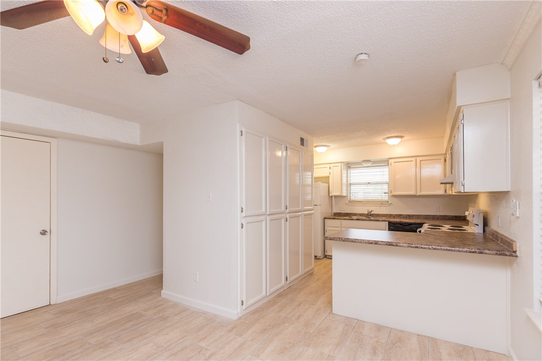 5133 Middlecoff Circle, Unit B Corpus Christi, TX 78413 - Photo 5 of 29 a kitchen with kitchen island white cabinets and refrigerator