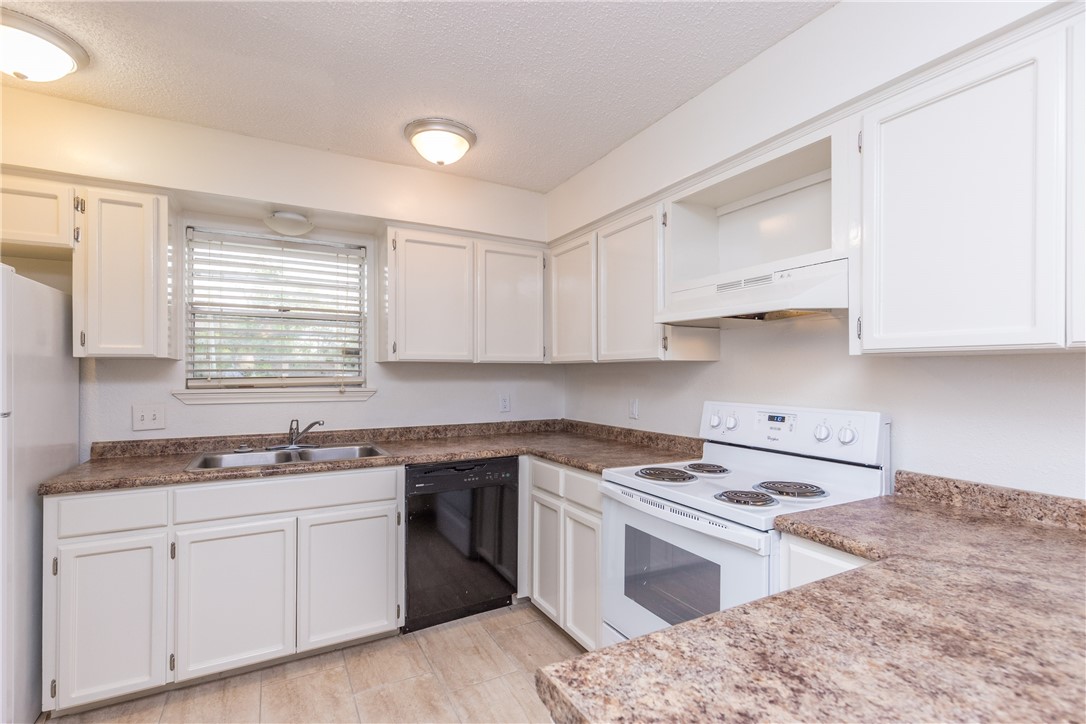 5133 Middlecoff Circle, Unit B Corpus Christi, TX 78413 - Photo 9 of 29 a kitchen with cabinets appliances a sink and a window
