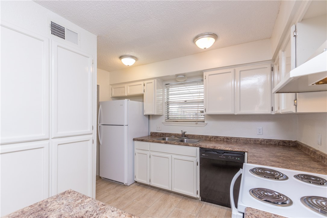 5133 Middlecoff Circle, Unit B Corpus Christi, TX 78413 - Photo 10 of 29 a kitchen with a refrigerator and a sink