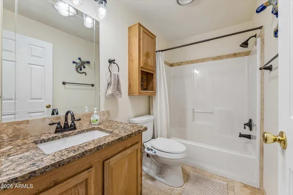 a bathroom with a granite countertop sink toilet and shower