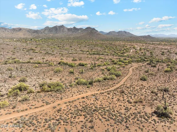an aerial view of a house with yard and mountain view in back