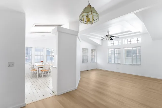 a view of dining room with wooden floor and chandelier