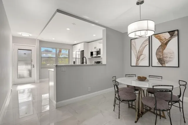 a dining room with wooden floor and large windows