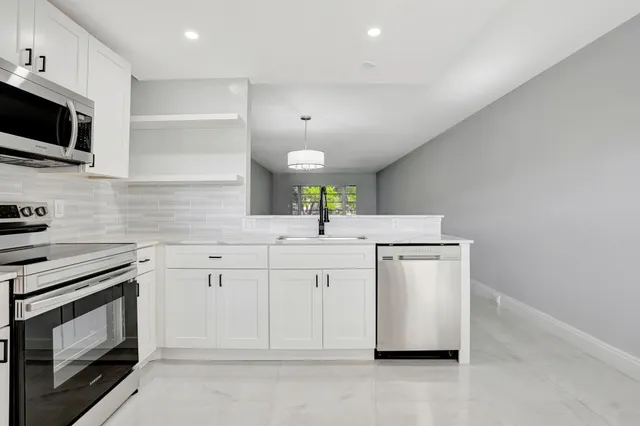 a kitchen with stainless steel appliances white cabinets and a sink
