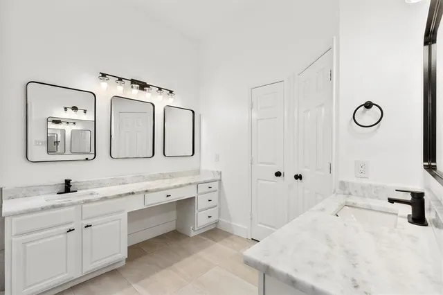 a spacious bathroom with a double vanity sink mirror and bathtub