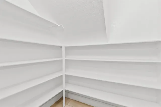 a view of walk in closet with empty racks