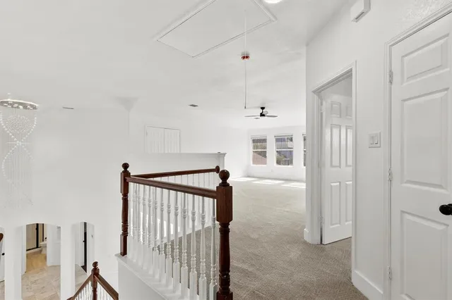 a view of a hallway with white cabinets
