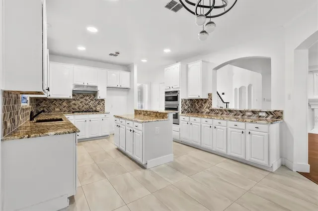 a kitchen with white cabinets appliances and a sink