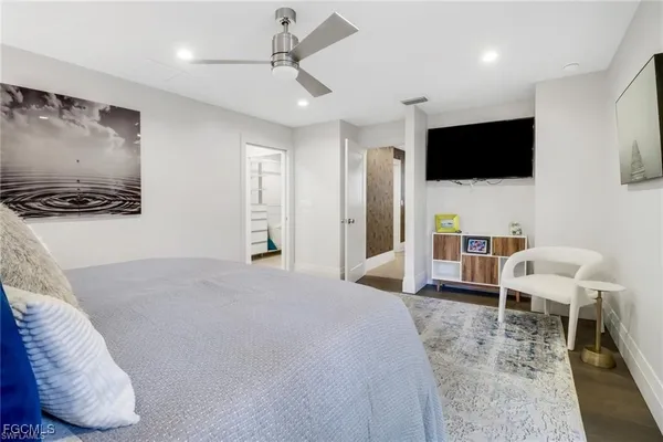 a bedroom with a bed tv and chair