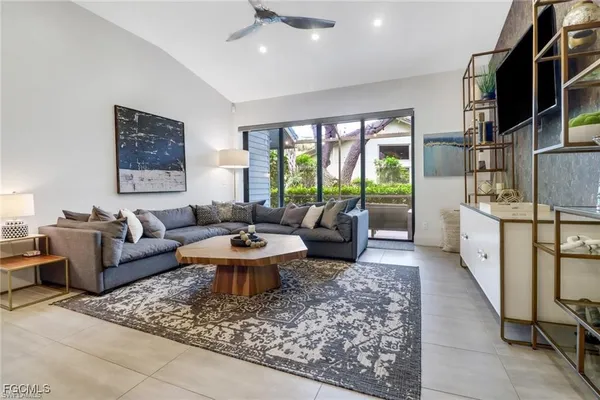 a living room with furniture a rug and a large window