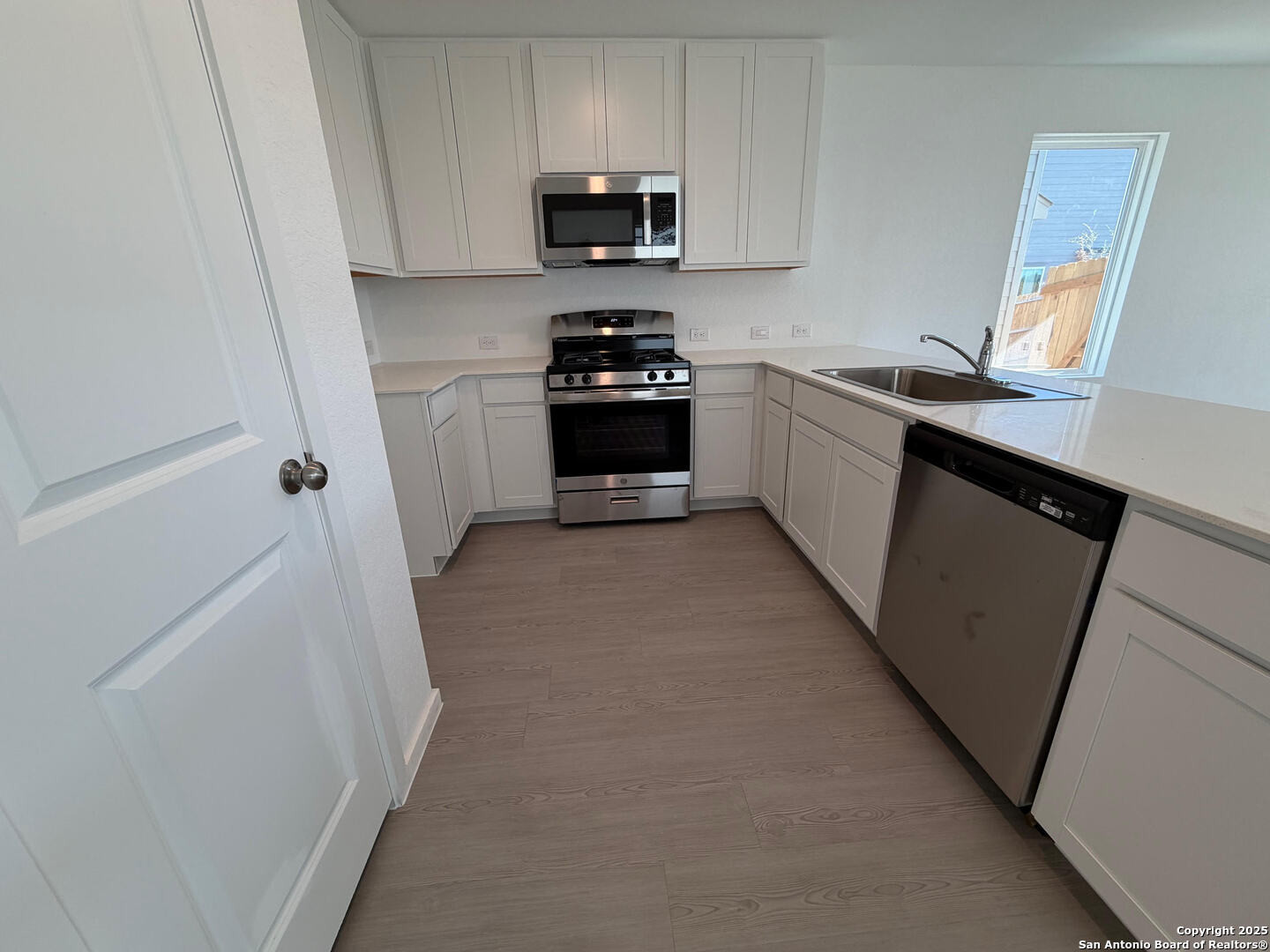 11910 Bluebell Ridge Converse, TX 78109 - Photo 3 of 15 a kitchen with white cabinets and stainless steel appliances