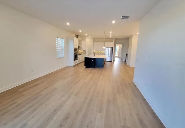 a view of a big room with wooden floor and windows