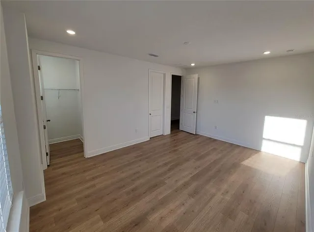 a view of empty room with wooden floor