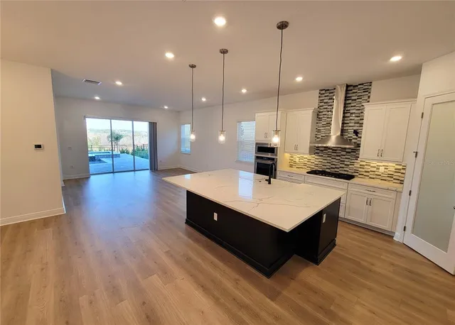 a kitchen with kitchen island white cabinets and sink