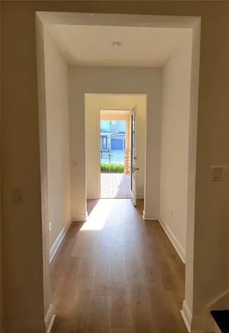 a view of a hallway with wooden floor