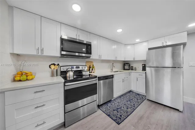 a kitchen with stainless steel appliances granite countertop a refrigerator sink and stove top oven