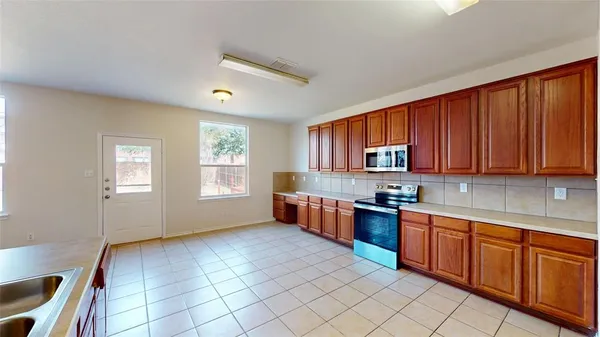 a kitchen with stainless steel appliances granite countertop a stove a sink dishwasher and cabinets with wooden floor