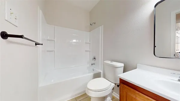 a white toilet sitting next to a bathroom sink and a shower