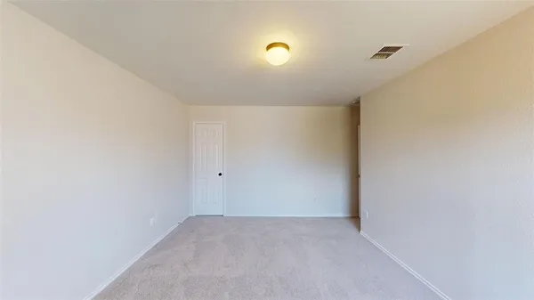 an empty room with chandelier fan and windows