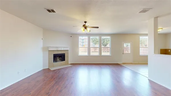 wooden floor fireplace and windows in an empty room
