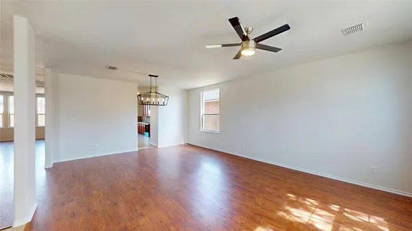 a view of a livingroom with a ceiling fan and wooden floor