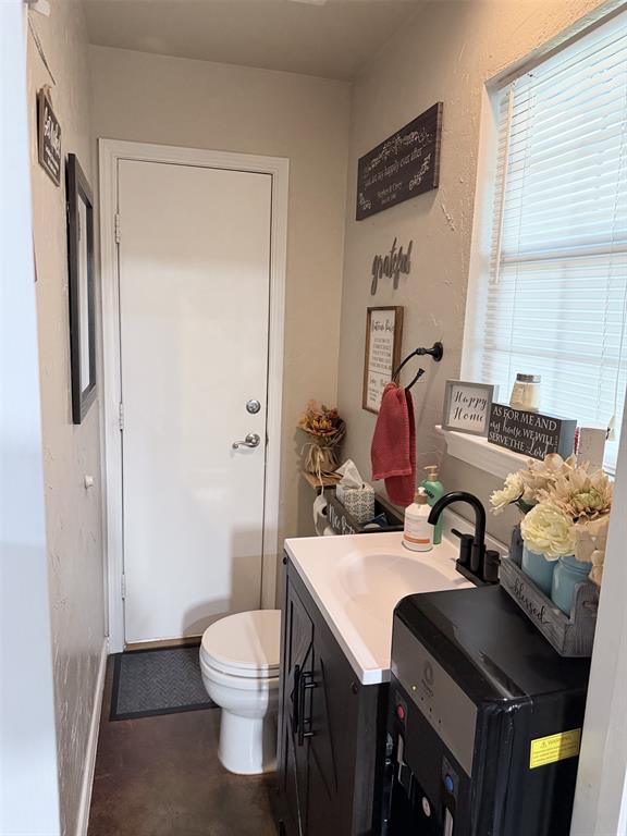 313 An County Road, Unit 2145 Palestine, TX 75801 - Photo 11 of 40 Window with blinds, integrated sink and countertop, dark wood-finish vanity with cabinet storage, contemporary black faucet, and white toilet
