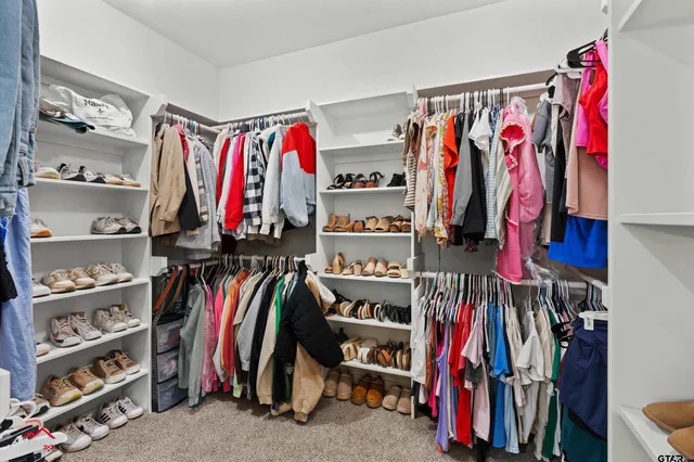 a view of walk in closet with clothes