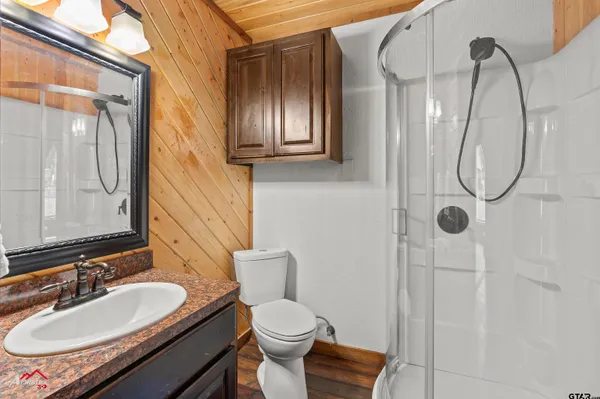 a bathroom with a granite countertop sink toilet and shower